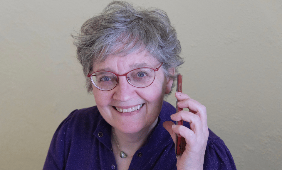 Workshopbegeleider Irma met telefoon in hand, klaar om jouw vragen over 'Jammie' te beantwoorden.
